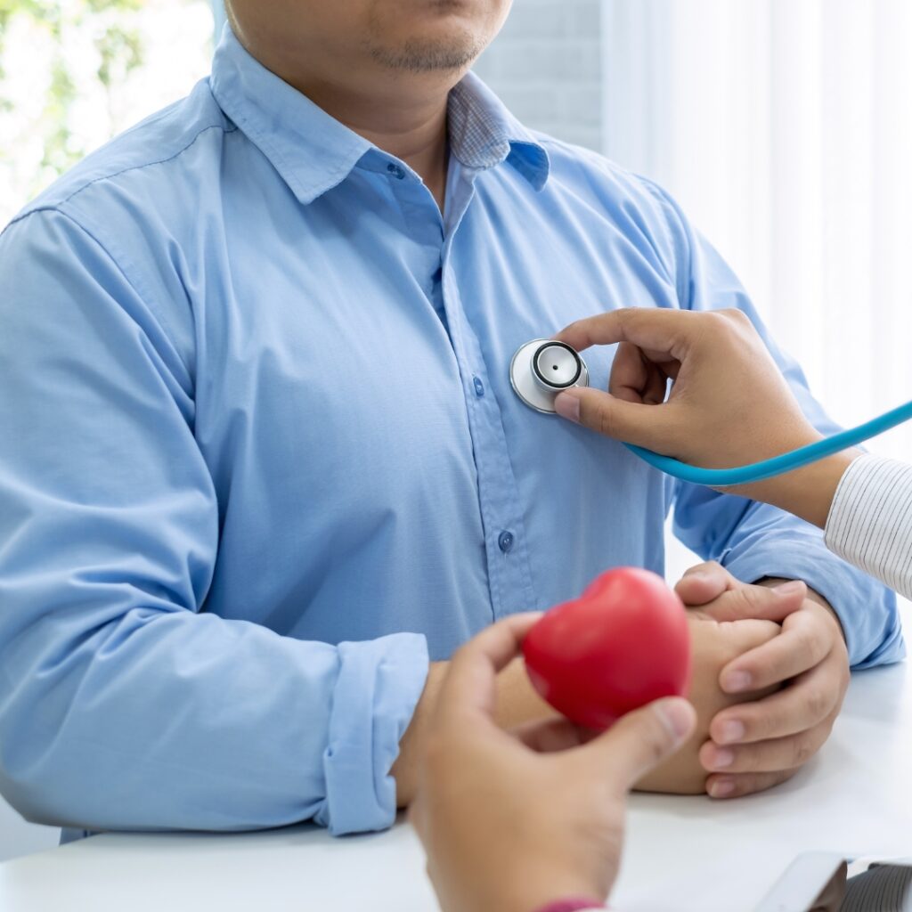 A doctor listens to their patient's heart.