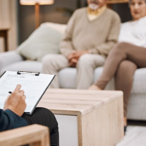 A couple sit on a couch and listen to their dietitian.