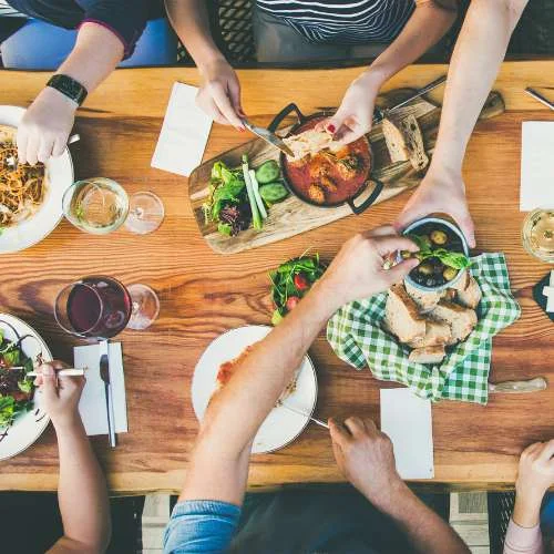 A group of people sit around a table and enjoy a meal.